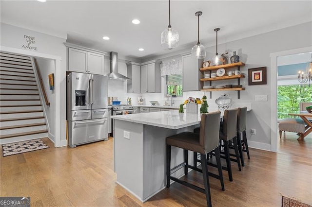 100 Yunsoo Pl E, Big Canoe, GA 30143 - kitchen featuring stainless steel refrigerator with ice dispenser, wall chimney range hood, a kitchen breakfast bar, recessed lighting, and light wood finished floors