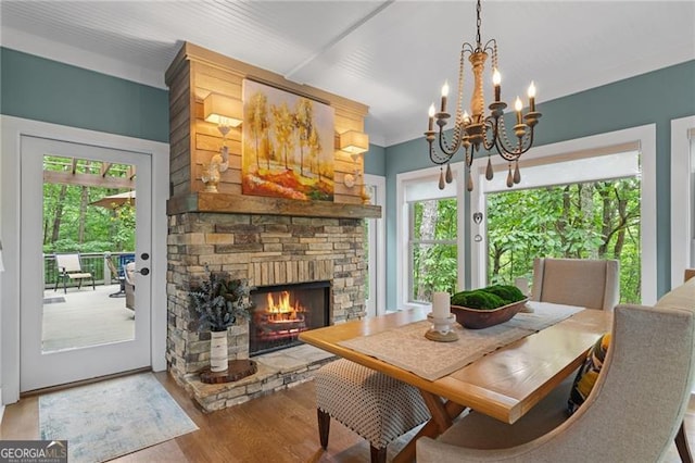 100 Yunsoo Pl E, Big Canoe, GA 30143 - dining space with wood finished floors, a chandelier, and a stone fireplace