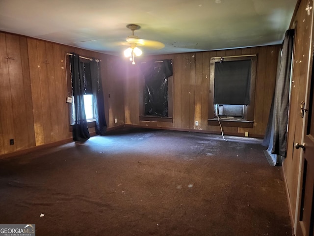 288 7th Ave, Winder, GA 30680 - unfurnished living room featuring wooden walls, carpet, a ceiling fan, and baseboards