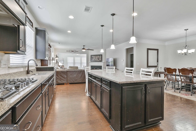 819 Firefly Ct, Griffin, GA 30223 - kitchen featuring a ceiling fan, dark wood-type flooring, stainless steel gas stovetop, decorative light fixtures, and a chandelier