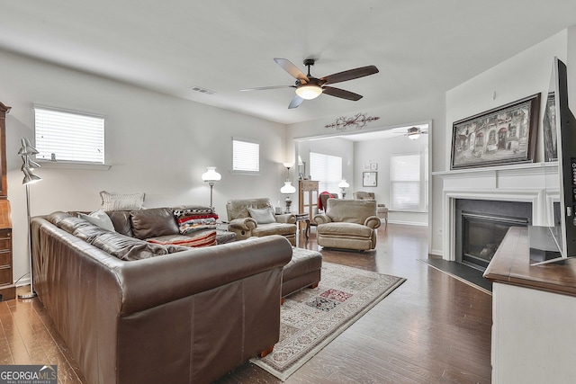 819 Firefly Ct, Griffin, GA 30223 - living room with a ceiling fan, dark wood-style flooring, and a glass covered fireplace