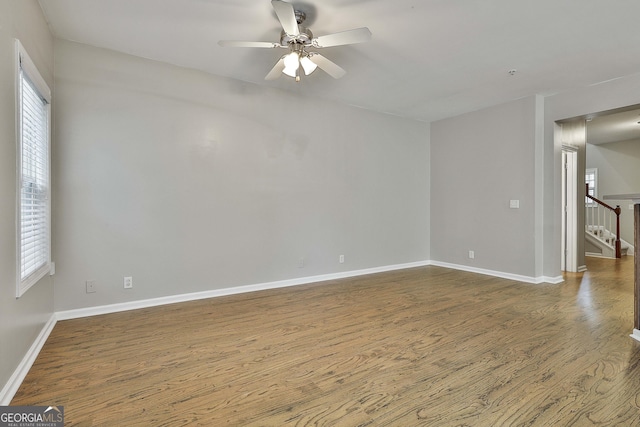 136 Granite Way, Newnan, GA 30265 - empty room featuring dark wood-style flooring, a ceiling fan, baseboards, and stairs