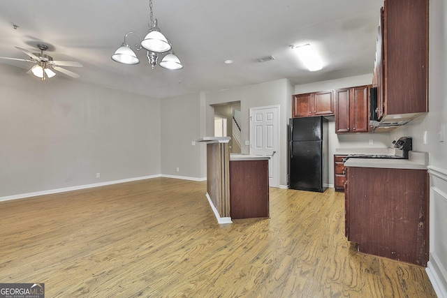 136 Granite Way, Newnan, GA 30265 - kitchen featuring freestanding refrigerator, light wood-type flooring, light countertops, hanging light fixtures, and baseboards