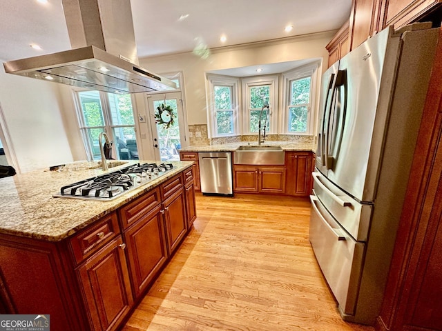 4265 Lansmoore, Suwanee, GA 30024 - kitchen featuring stainless steel appliances, island exhaust hood, light wood finished floors, light stone counters, and ornamental molding