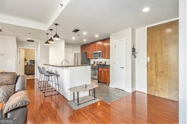 171 Auburn Ave NE Unit 521, Atlanta, GA 30303 - kitchen with stainless steel appliances, dark countertops, dark wood finished floors, a breakfast bar, and recessed lighting