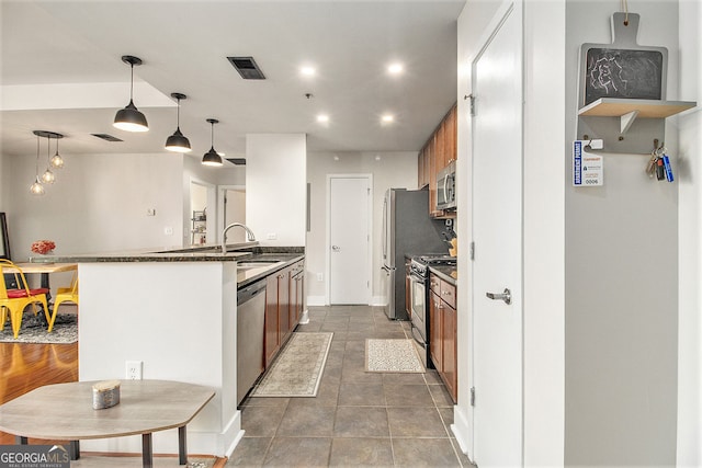 171 Auburn Ave NE Unit 521, Atlanta, GA 30303 - kitchen with appliances with stainless steel finishes, recessed lighting, brown cabinetry, a peninsula, and pendant lighting