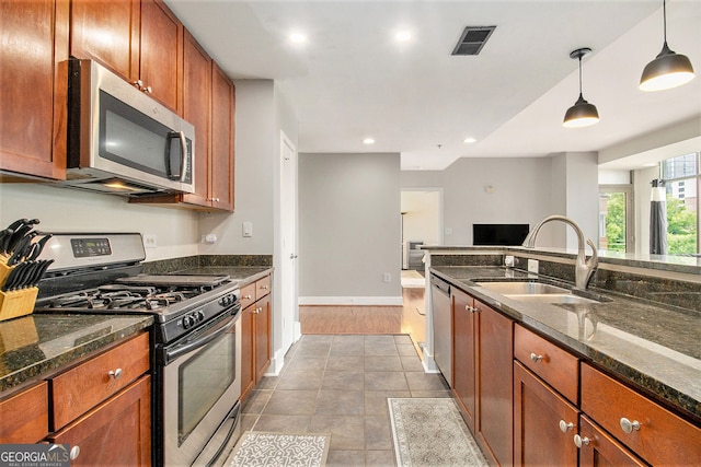 171 Auburn Ave NE Unit 521, Atlanta, GA 30303 - kitchen with appliances with stainless steel finishes, decorative light fixtures, dark stone countertops, brown cabinetry, and recessed lighting