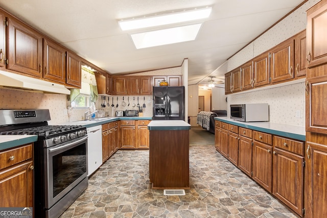 294 Birch Rd, Franklin, GA 30217 - kitchen featuring gas range, black refrigerator with ice dispenser, stone floors, a center island, and lofted ceiling