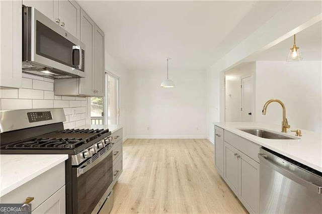 4523 Doc Sams Rd, Cumming, GA 30028 - kitchen with stainless steel appliances, a sink, tasteful backsplash, baseboards, and light wood finished floors