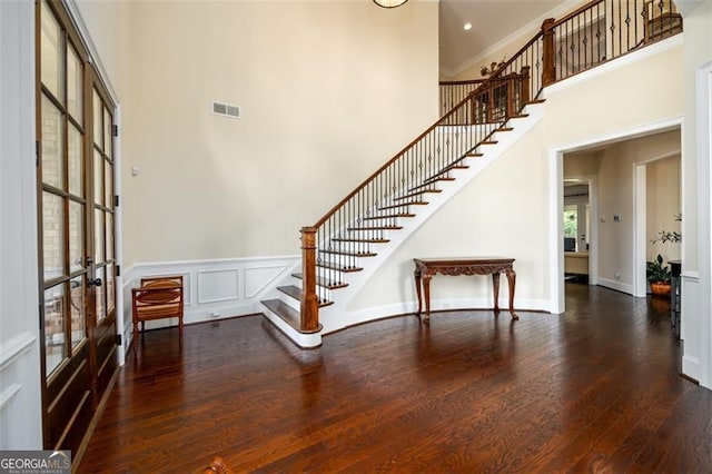 6110 Read Rd, Suwanee, GA 30024 - foyer entrance with stairway, a towering ceiling, wood finished floors, french doors, and wainscoting