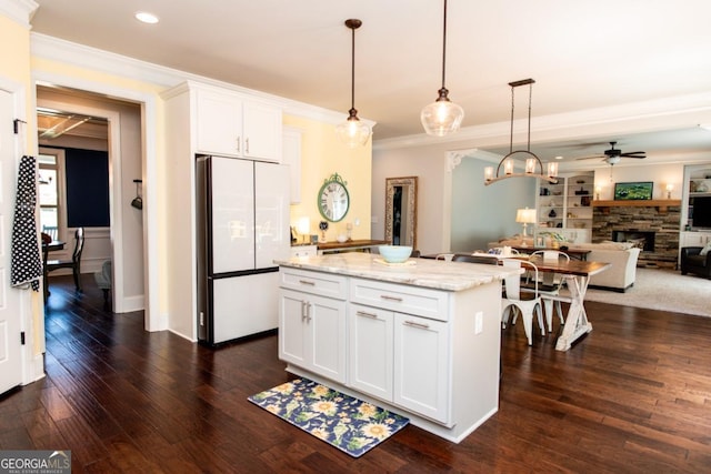 1032 Switchgrass Dr, Statham, GA 30666 - kitchen featuring freestanding refrigerator, a ceiling fan, crown molding, a stone fireplace, and a kitchen island