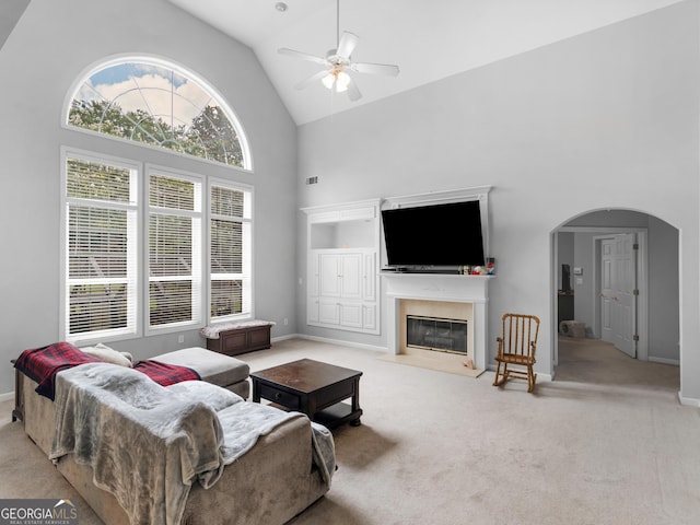 1613 Brolington Ct, Conyers, GA 30013 - carpeted living room featuring high vaulted ceiling, arched walkways, a ceiling fan, and a fireplace