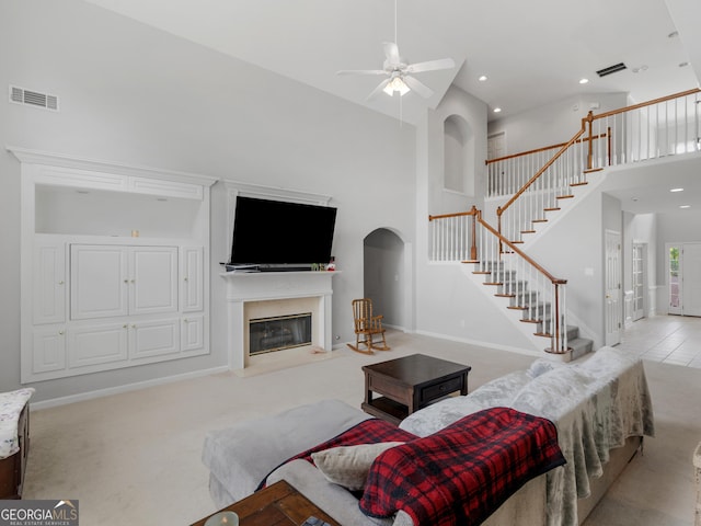 1613 Brolington Ct, Conyers, GA 30013 - living room featuring a high ceiling, stairway, a premium fireplace, a ceiling fan, and arched walkways