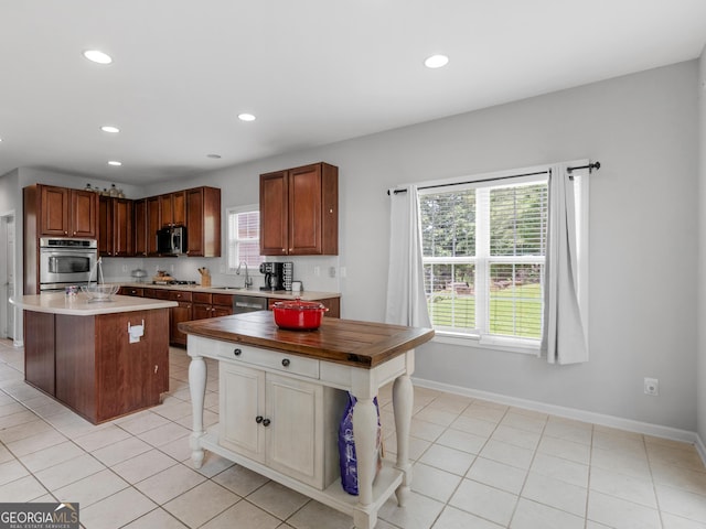 1613 Brolington Ct, Conyers, GA 30013 - kitchen with stainless steel appliances, a center island, light tile patterned floors, recessed lighting, and wood counters