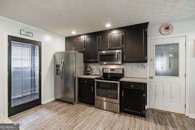 82 Post Oak Cir, Crawford, GA 30630 - kitchen with stainless steel appliances, light wood-style flooring, tasteful backsplash, baseboards, and crown molding