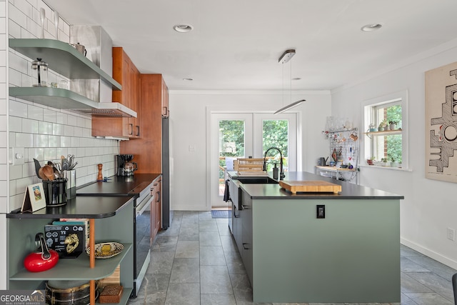 278 Fourth St, Athens, GA 30601 - kitchen with dark countertops, a center island with sink, brown cabinetry, backsplash, and recessed lighting