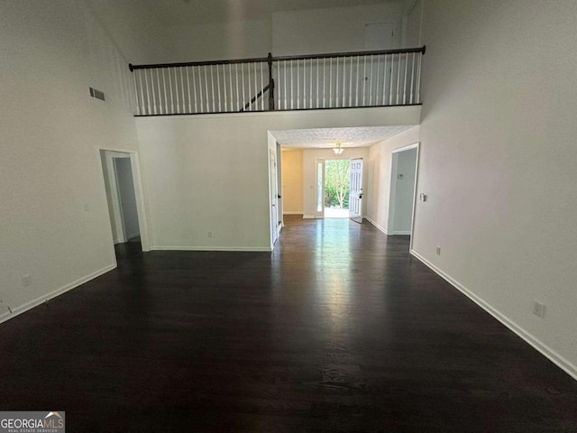 11 Long Branch Xing, Dahlonega, GA 30533 - unfurnished living room featuring dark wood-style floors, baseboards, and a high ceiling