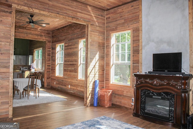 1048 Whites Mill Rd, Valley, AL 36854 - living area with wood walls, wood finished floors, a glass covered fireplace, wooden ceiling, and a ceiling fan