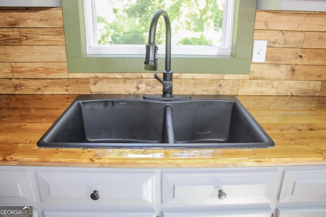 1048 Whites Mill Rd, Valley, AL 36854 - kitchen view of a sink, white cabinetry, and wood walls