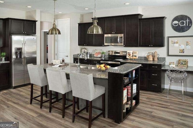 614A E Lake Dr, Gainesville, GA 30506 - kitchen with stainless steel appliances, a breakfast bar, dark stone countertops, wood finished floors, and recessed lighting