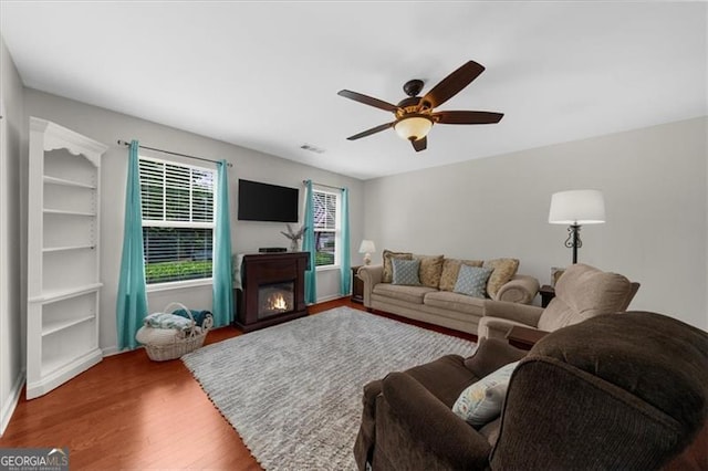 397 Cypher Dr, Suwanee, GA 30024 - living area featuring wood finished floors, ceiling fan, and a glass covered fireplace