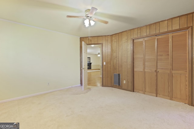 2317 Ga Highway 24, Statesboro, GA 30461 - unfurnished bedroom featuring carpet flooring, wooden walls, a closet, crown molding, and a ceiling fan