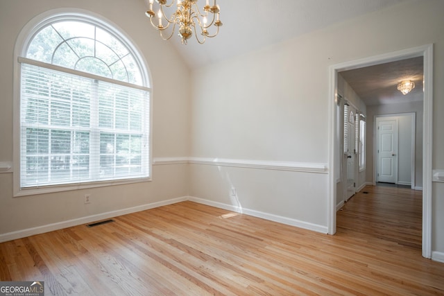 2021 Windfield Dr, Monroe, GA 30655 - empty room featuring a chandelier, plenty of natural light, wood finished floors, and lofted ceiling