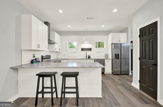 92 Autumn Path, Rockmart, GA 30153 - kitchen featuring stainless steel appliances, a peninsula, wall chimney exhaust hood, decorative backsplash, and recessed lighting
