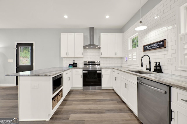92 Autumn Path, Rockmart, GA 30153 - kitchen with appliances with stainless steel finishes, wall chimney range hood, a peninsula, tasteful backsplash, and recessed lighting