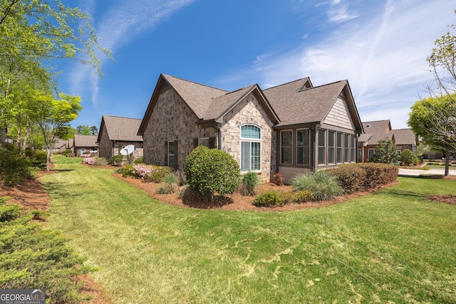 328 Brookhaven Walk, Johns Creek, GA 30097 - view of side of property featuring stone siding, roof with shingles, a lawn, and a sunroom