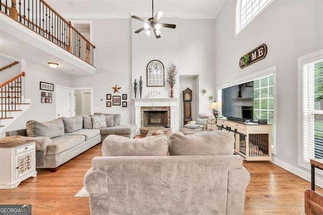 125 Shamus Way, Jefferson, GA 30549 - living area featuring ceiling fan, a fireplace, a high ceiling, stairway, and crown molding