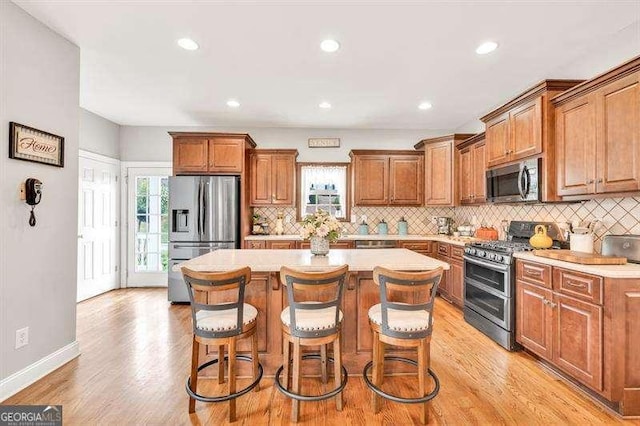125 Shamus Way, Jefferson, GA 30549 - kitchen with appliances with stainless steel finishes, a center island, tasteful backsplash, brown cabinets, and recessed lighting