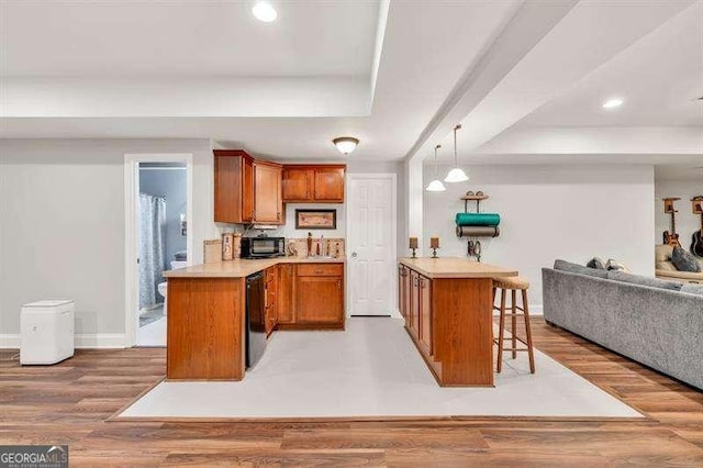 125 Shamus Way, Jefferson, GA 30549 - kitchen featuring a tray ceiling, a peninsula, open floor plan, brown cabinetry, and recessed lighting