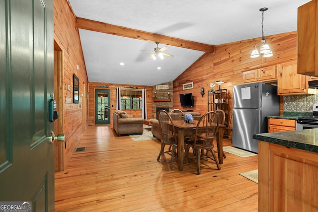 242 Eagles Nest Rd, Sautee Nacoochee, GA 30571 - dining space with wooden walls, light wood-type flooring, a ceiling fan, and a fireplace