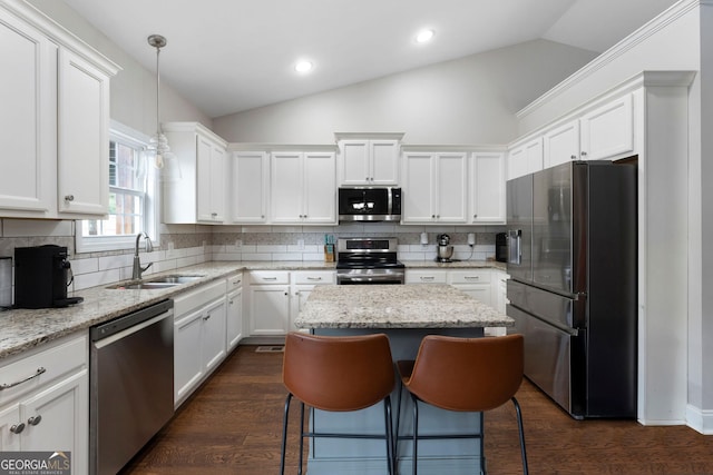 521 Peeples Valley Rd NW, Cartersville, GA 30121 - kitchen featuring stainless steel appliances, vaulted ceiling, white cabinetry, a kitchen island, and decorative backsplash
