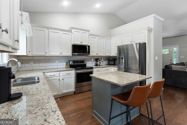 521 Peeples Valley Rd NW, Cartersville, GA 30121 - kitchen with appliances with stainless steel finishes, white cabinets, a kitchen bar, tasteful backsplash, and vaulted ceiling