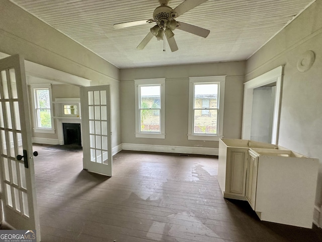 310 Butler St, Waycross, GA 31501 - spare room with dark wood-style floors, a ceiling fan, french doors, and a fireplace