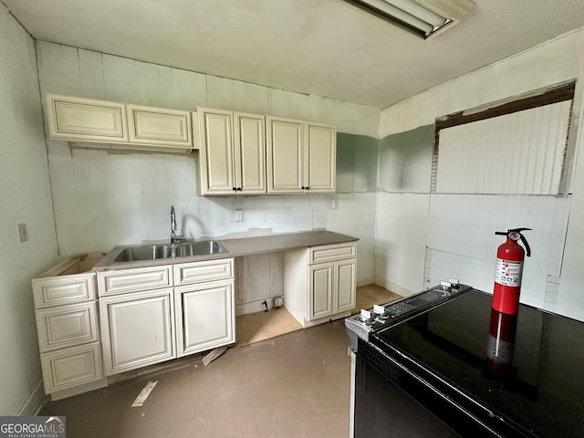 310 Butler St, Waycross, GA 31501 - kitchen with black electric range oven, cream cabinets, and finished concrete floors