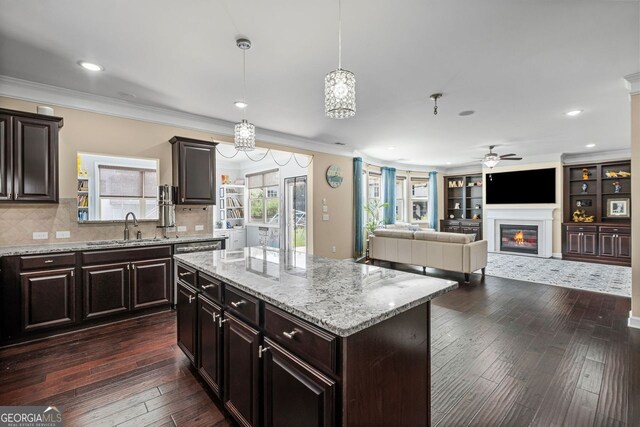 745 Newfield Ln, Alpharetta, GA 30004 - kitchen featuring a ceiling fan, ornamental molding, dark wood-type flooring, a glass covered fireplace, and light stone countertops