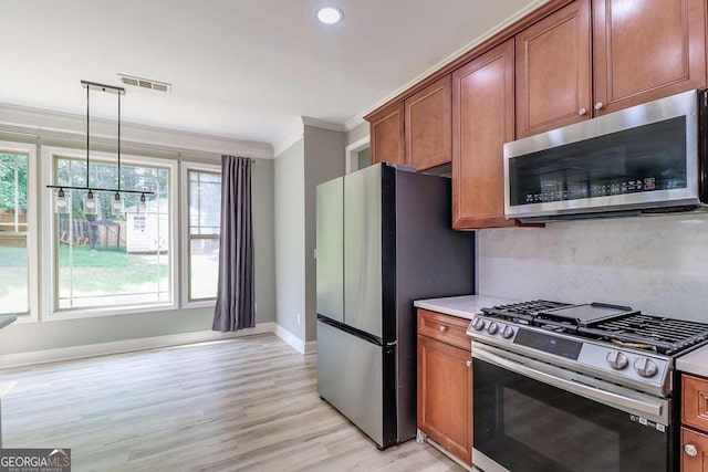 95 Jeffco Dr, Jefferson, GA 30549 - kitchen with appliances with stainless steel finishes, ornamental molding, brown cabinets, light wood-style flooring, and light countertops