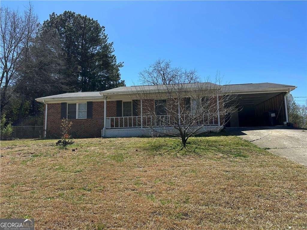 726 Shoreline Trl SE, Conyers, GA 30094 - single story home with concrete driveway, a front lawn, a carport, brick siding, and covered porch