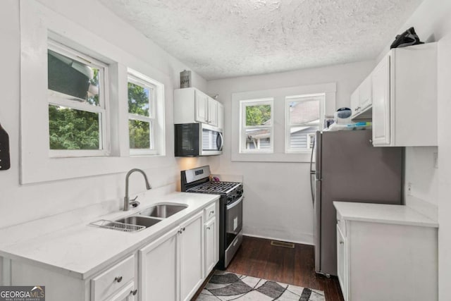 1192 Arlington Ave SW, Atlanta, GA 30310 - kitchen with appliances with stainless steel finishes, a sink, plenty of natural light, dark wood-style flooring, and a textured ceiling