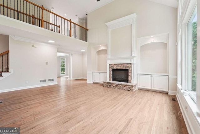 4508 Meadow Vista Trce, Lithonia, GA 30038 - unfurnished living room with a high ceiling, light wood-type flooring, stairway, a stone fireplace, and baseboards