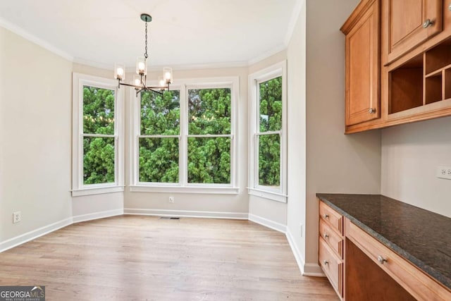 4508 Meadow Vista Trce, Lithonia, GA 30038 - unfurnished dining area featuring healthy amount of natural light, a chandelier, light wood-style flooring, ornamental molding, and baseboards