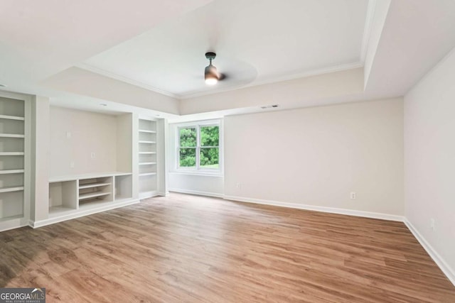 4508 Meadow Vista Trce, Lithonia, GA 30038 - unfurnished living room featuring built in shelves, ornamental molding, wood finished floors, and a raised ceiling