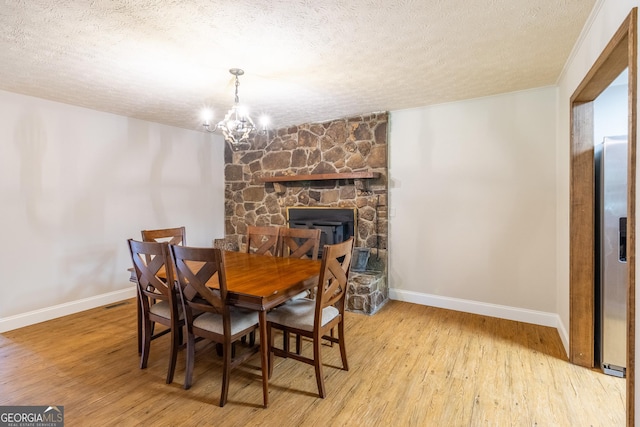 775 Mays Bridge Rd SW, Rome, GA 30165 - dining room with a textured ceiling, baseboards, wood finished floors, a chandelier, and a stone fireplace