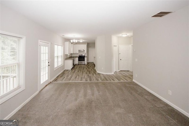 365 Hunt Crk, Acworth, GA 30101 - unfurnished living room featuring a chandelier, light carpet, baseboards, and a sink