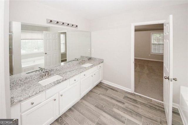 365 Hunt Crk, Acworth, GA 30101 - full bathroom featuring double vanity, a garden tub, wood tiled floors, and baseboards