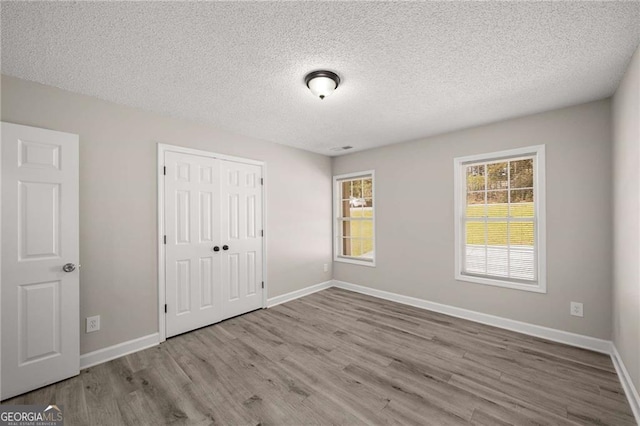1071 N Price Rd, Sugar Hill, GA 30518 - unfurnished bedroom featuring wood finished floors, a textured ceiling, and a closet