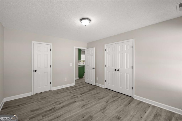 1071 N Price Rd, Sugar Hill, GA 30518 - unfurnished bedroom featuring wood finished floors, a textured ceiling, and a closet